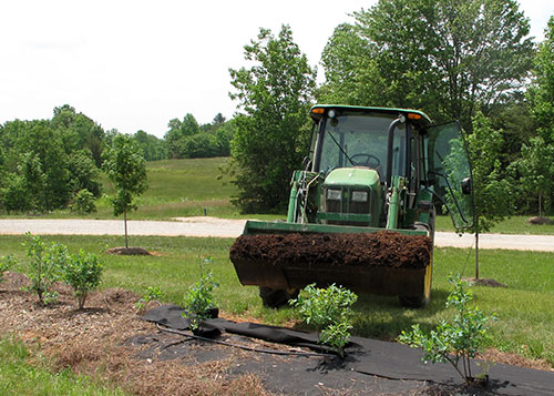 John Deere tractor with a scoop of mulch.